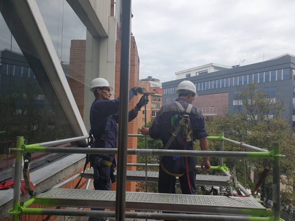 Técnico OVI limpiando una fachada en altura