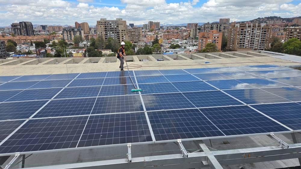 Técnico limpiando paneles solares en una cubierta